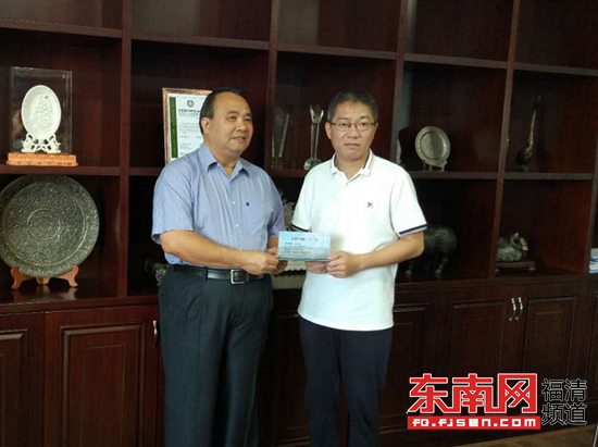 林俏立為祥興集團董事長薛行遠送上雙保行動連心卡（龍江街道辦事處供圖）